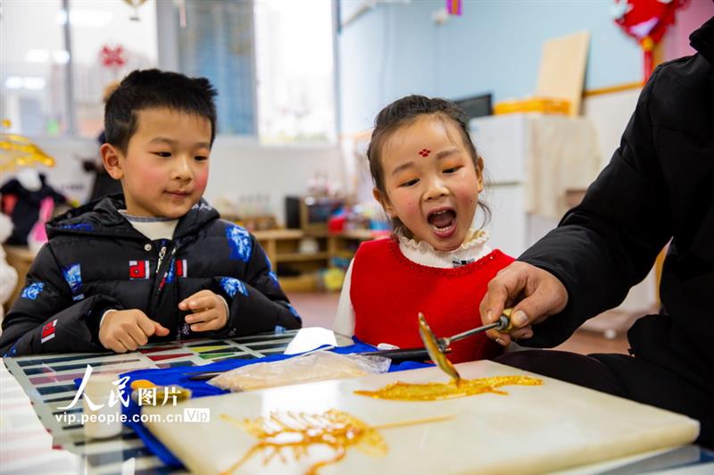 12月29日，孩子們在觀看糖人制作。