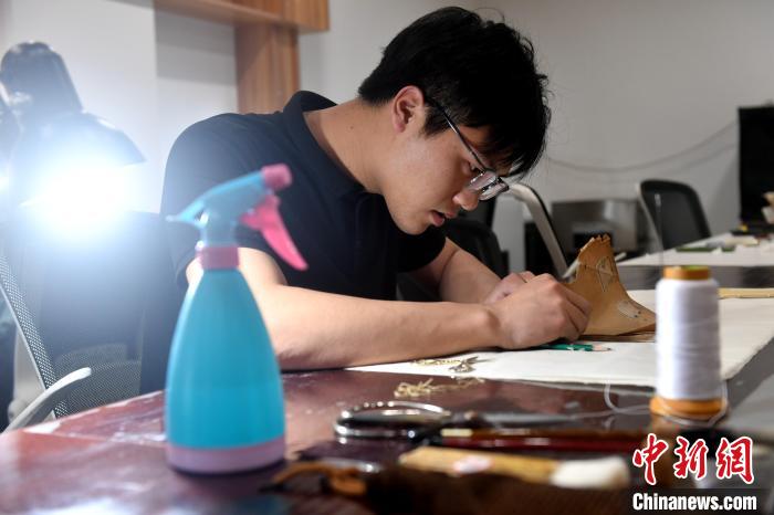 “90后”文物修復(fù)師瞿超正低頭手工修復(fù)民國時期影印的古籍《春秋繁露》。　呂明 攝