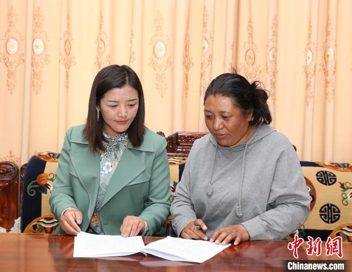 圖為扎囊養(yǎng)護(hù)段段長次旦卓瑪(左)正在與同事交流工作。　趙延 攝