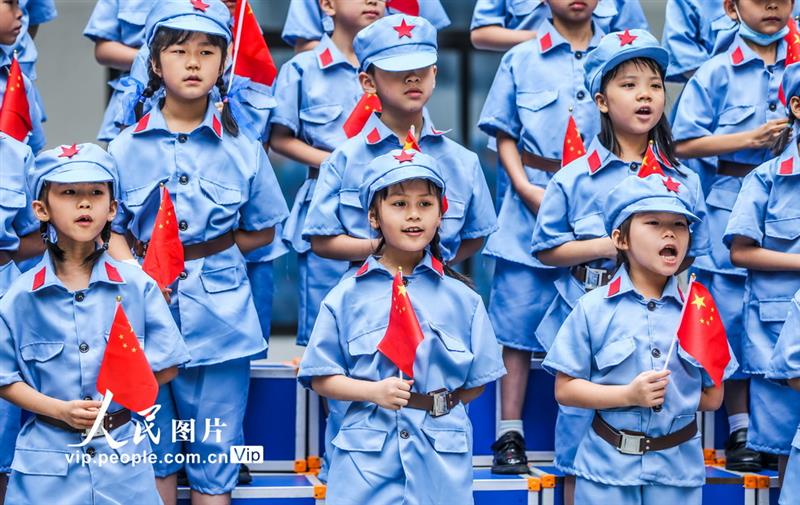 5月31日，南寧市濱湖路小學長虹校區的學生們揮舞國旗，唱響紅色歌曲。
