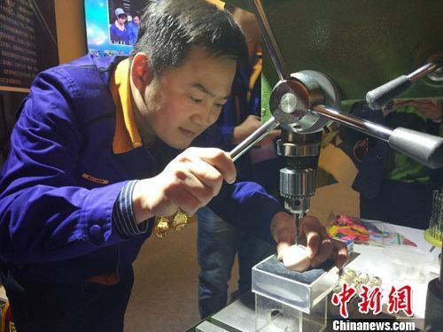 大國工匠張新停表演電鉆鉆雞蛋絕活。<a target='_blank' href='http://www.chinanews.com/' >中新網(wǎng)</a>記者 李金磊 攝 